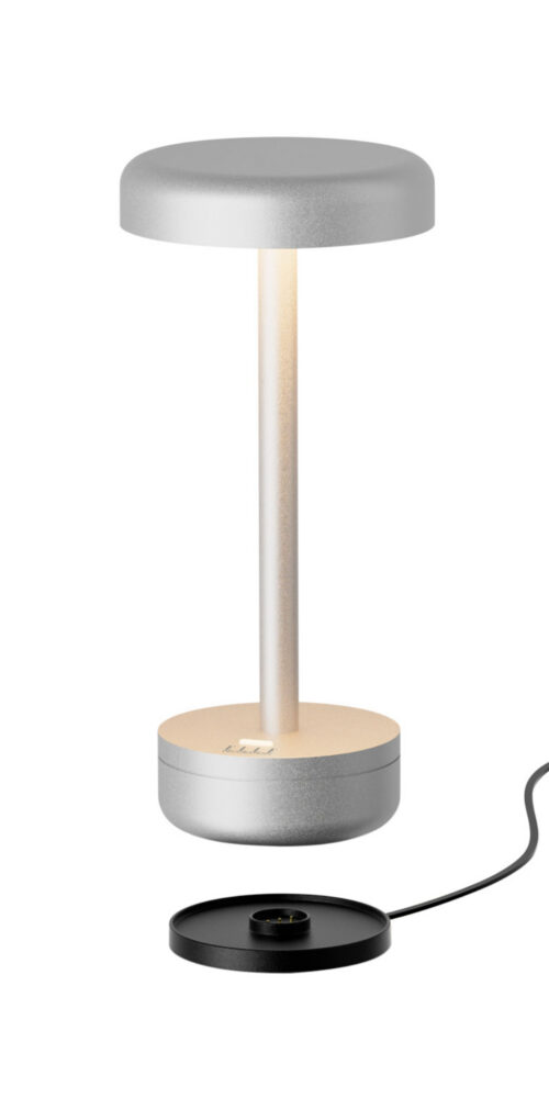 Matt silver IENA cordless table lamp from ELLE Decoration, shown above its separate black charging base.