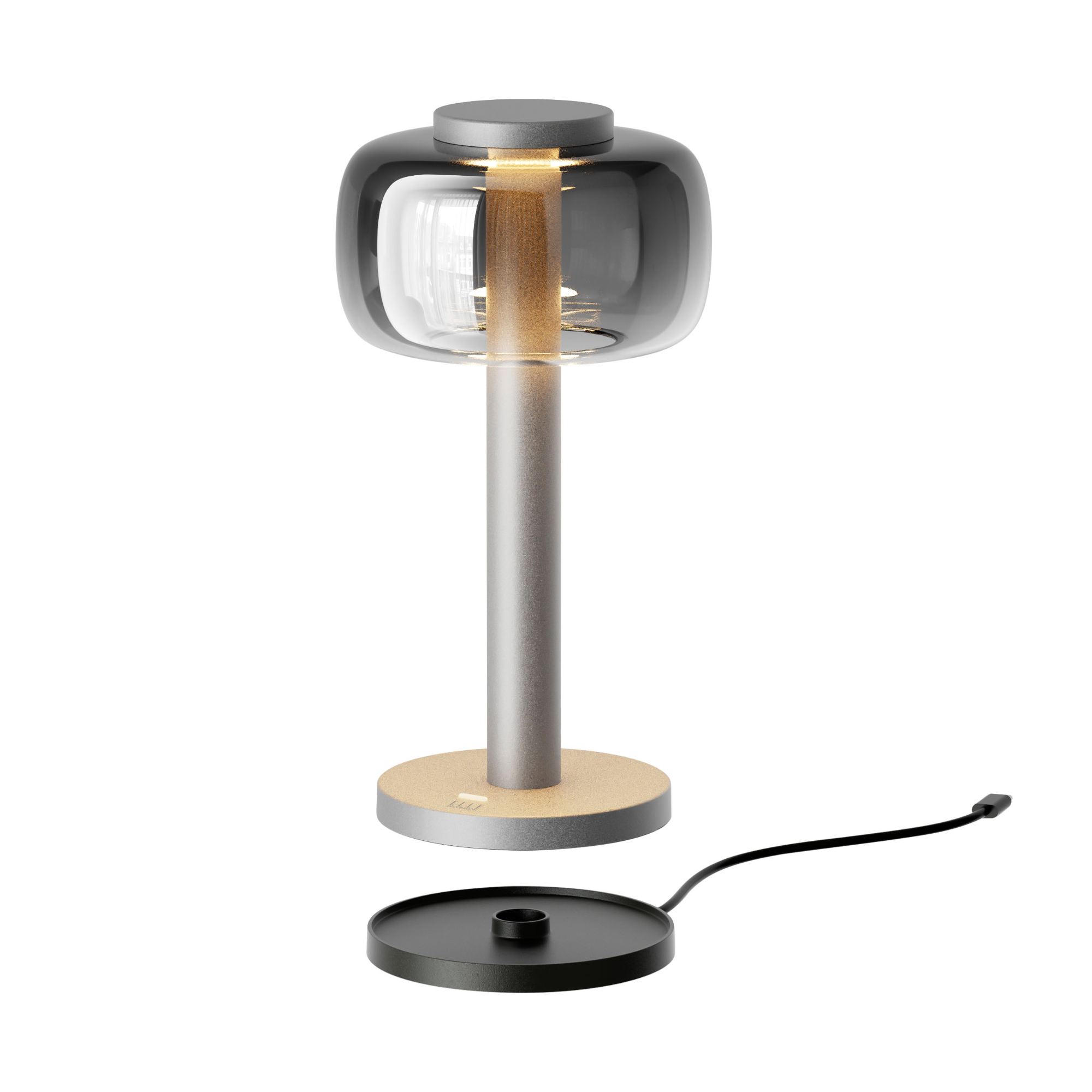 Matt silver ODEON cordless table lamp from ELLE Decoration with a smoked glass shade, shown above its separate black charging base.